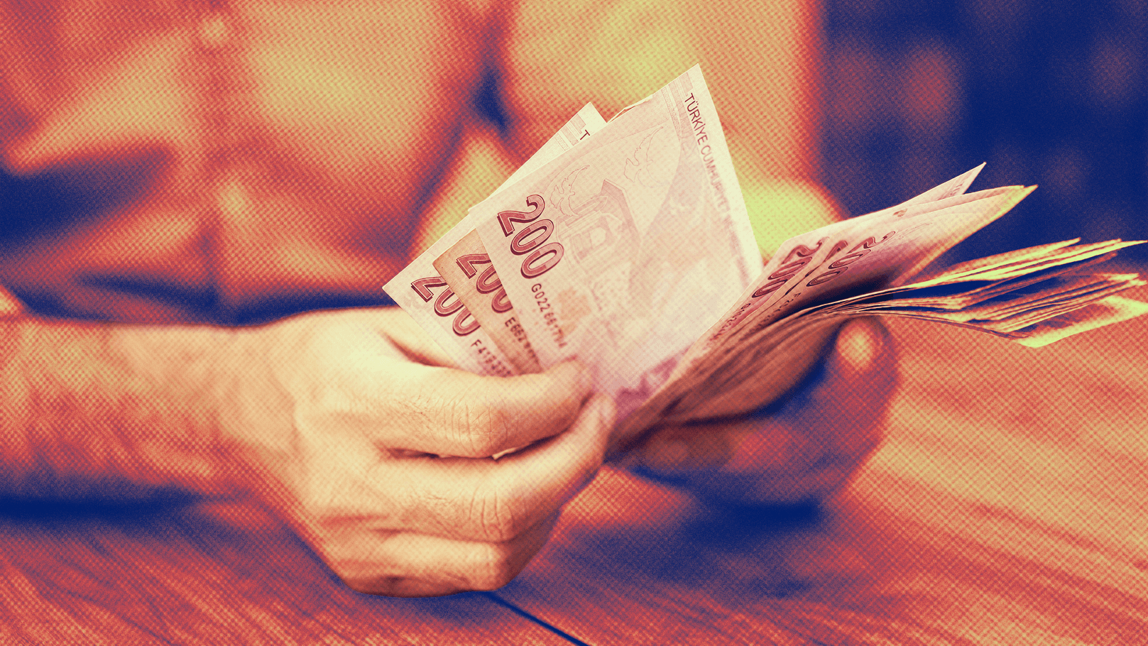 Elinde tuttuğu çeşitli değerlerdeki Euro banknotları gösteren el, dışarıda bulanık arka planda.